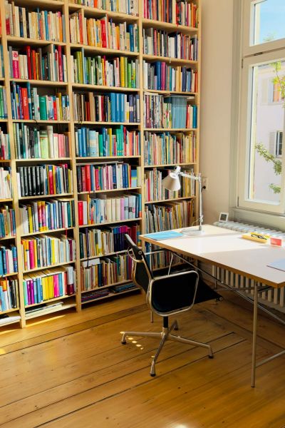 Bücherregal mit Schreibtisch am Fenster